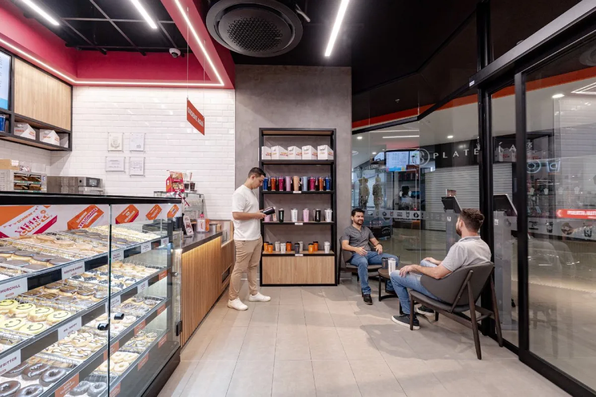 Dunkin Donuts - Modern retail interior with donut display cases and wood slat detailing - Contract Workplaces.webp